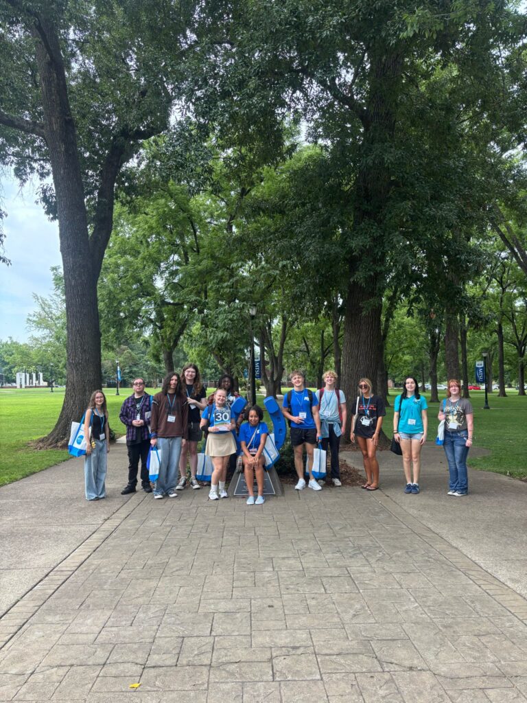Students in Group 30 of orientation posing for a photo at the blue horseshoe at MTSU with their Student Orientation Assistant.