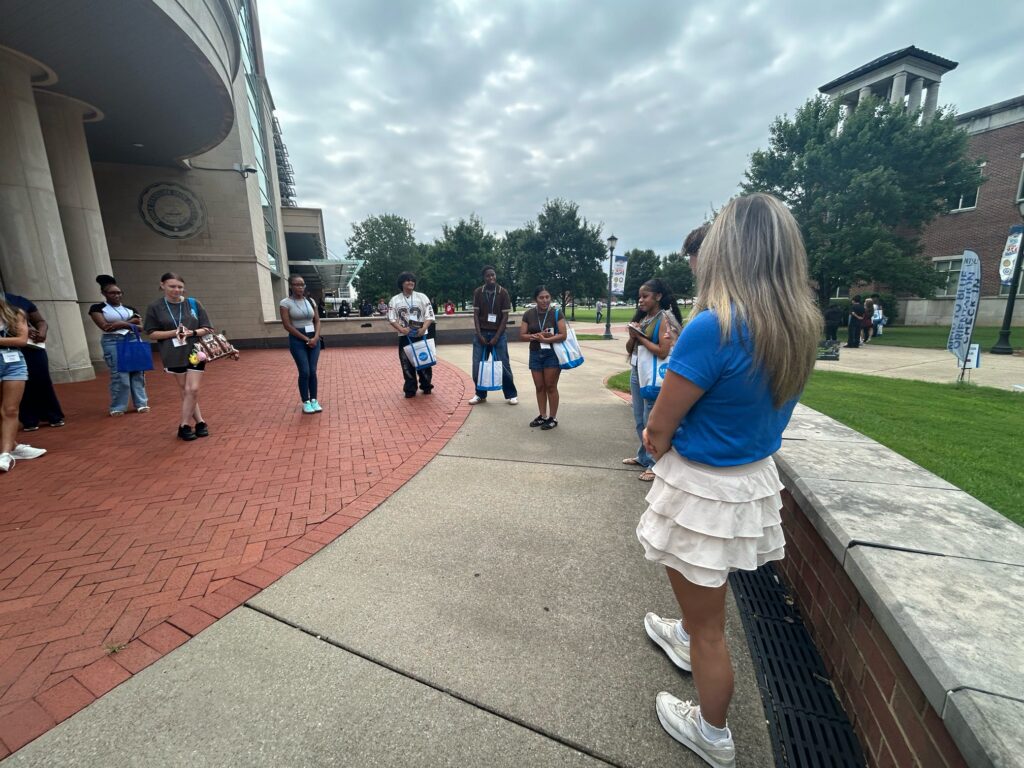 Students attending orientation standing outside the Student Union with their Student Orientation Assistant.
