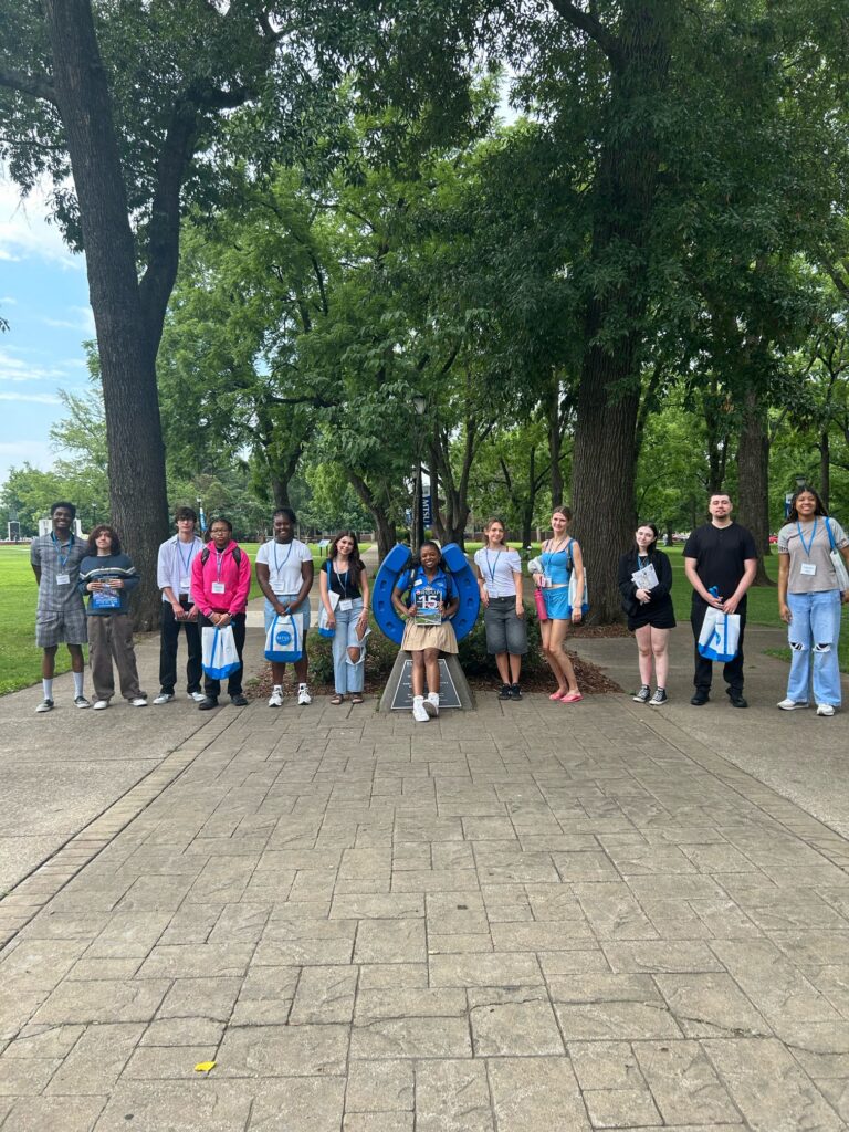Students in Group 15 of orientation posing for a photo at the blue horseshoe at MTSU with their Student Orientation Assistant.