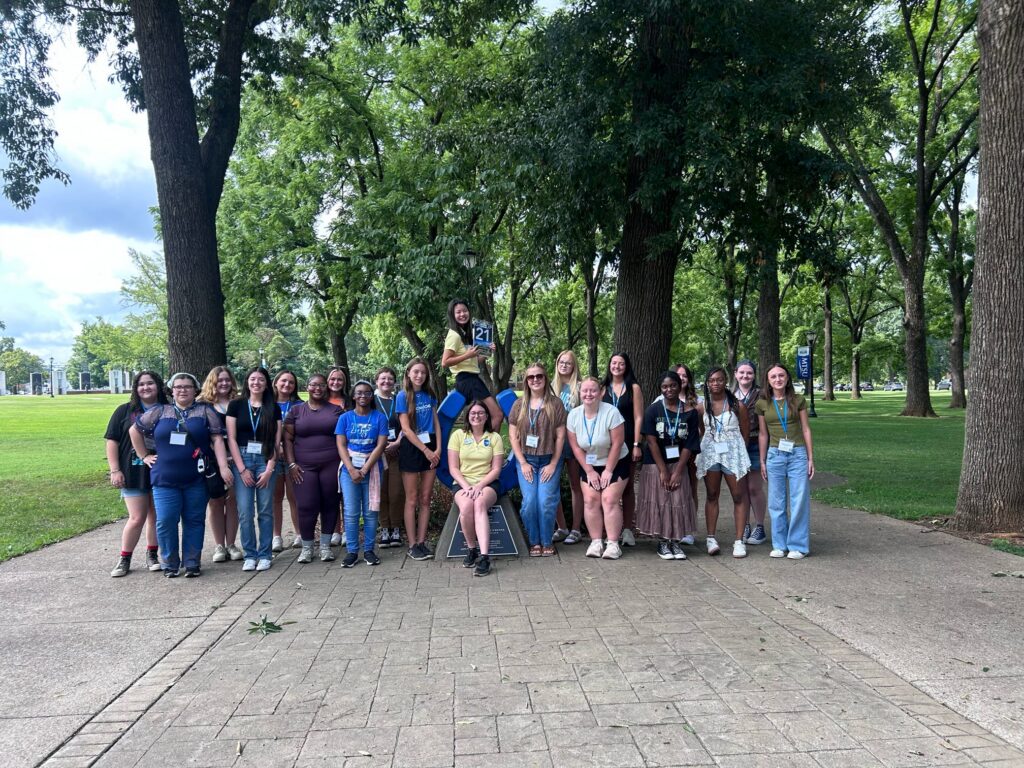 Students in Group 21 of orientation posing for a photo at the blue horseshoe at MTSU with their Student Orientation Assistant.