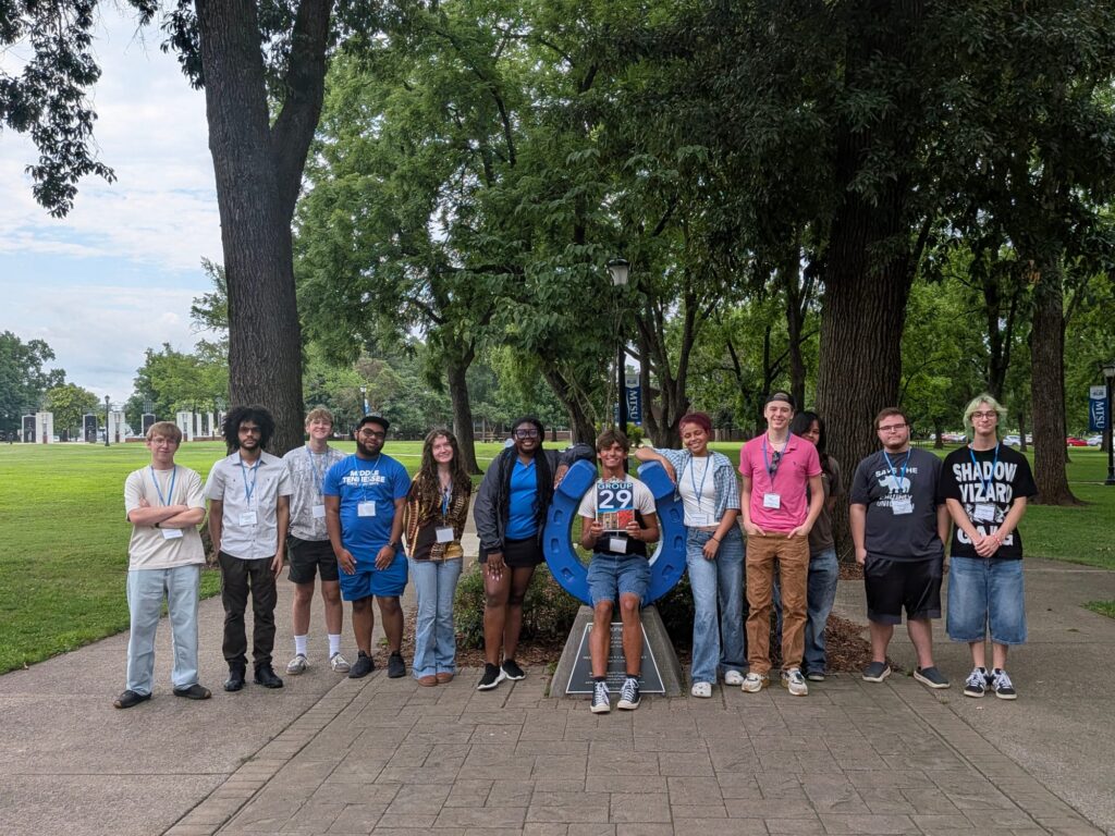Students in Group 29 of orientation posing for a photo at the blue horseshoe at MTSU with their Student Orientation Assistant.