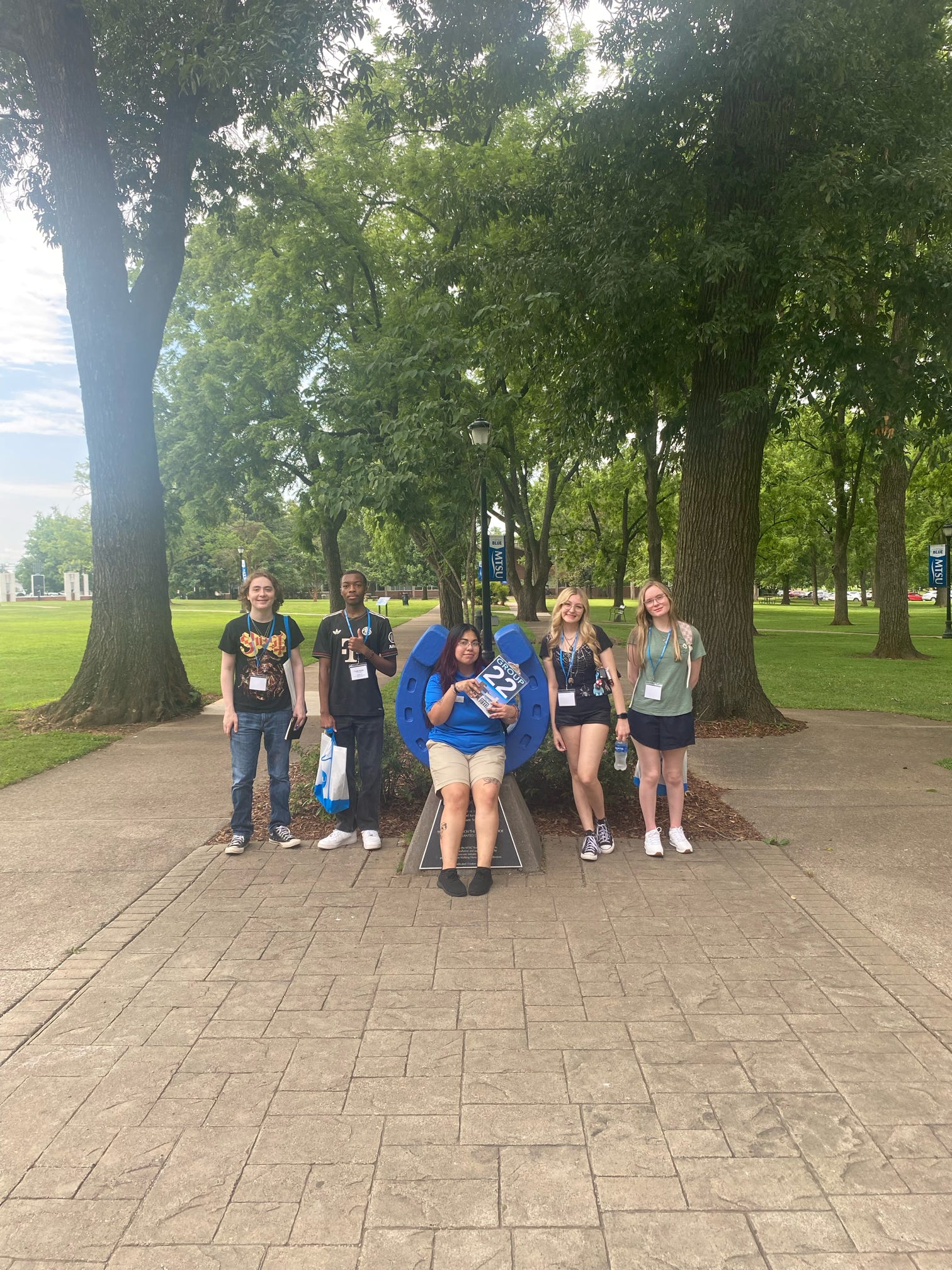 Students in Group 22 of orientation posing for a photo at the blue horseshoe at MTSU with their Student Orientation Assistant.