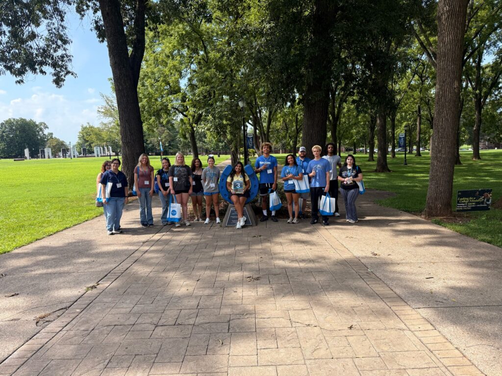 Students in Group 3 of orientation posing for a photo at the blue horseshoe at MTSU with their Student Orientation Assistant.