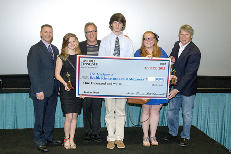 MTSU’s Billy Pittard and Metro Nashville Public Schools administrator Dr. Chaney Mosley present the Best in Show check for $1,000 to the Academy of Health Science and Law at McGavock. The presentation was made in April at the second annual Academies of Nashville Video Awards Show. Left to right are Mosley; Elise Taylor, a student at McGavock; Barclay Randall, broadcasting teacher at McGavock; Robert Bagwell, student at McGavock; DeLaney Williams, a student at McGavock, and Pittard, chair of MTSU’s Department of Electronic Media Communication. (MTSU file photo)