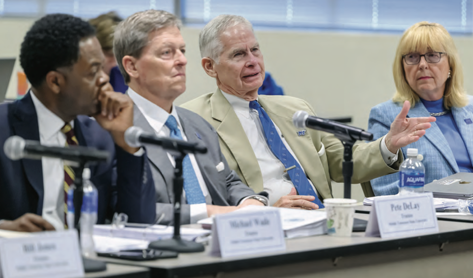 Board of Trustees behind microphones during a meeting