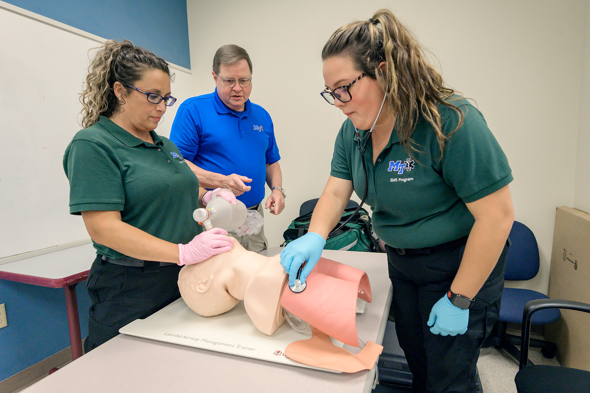 Two students and an instructor work during an EMT class at MTSU