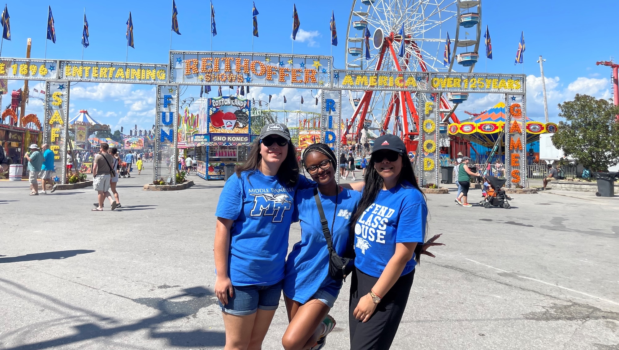 3 Public Health BS students wearing MTSU T-shirts at a fair