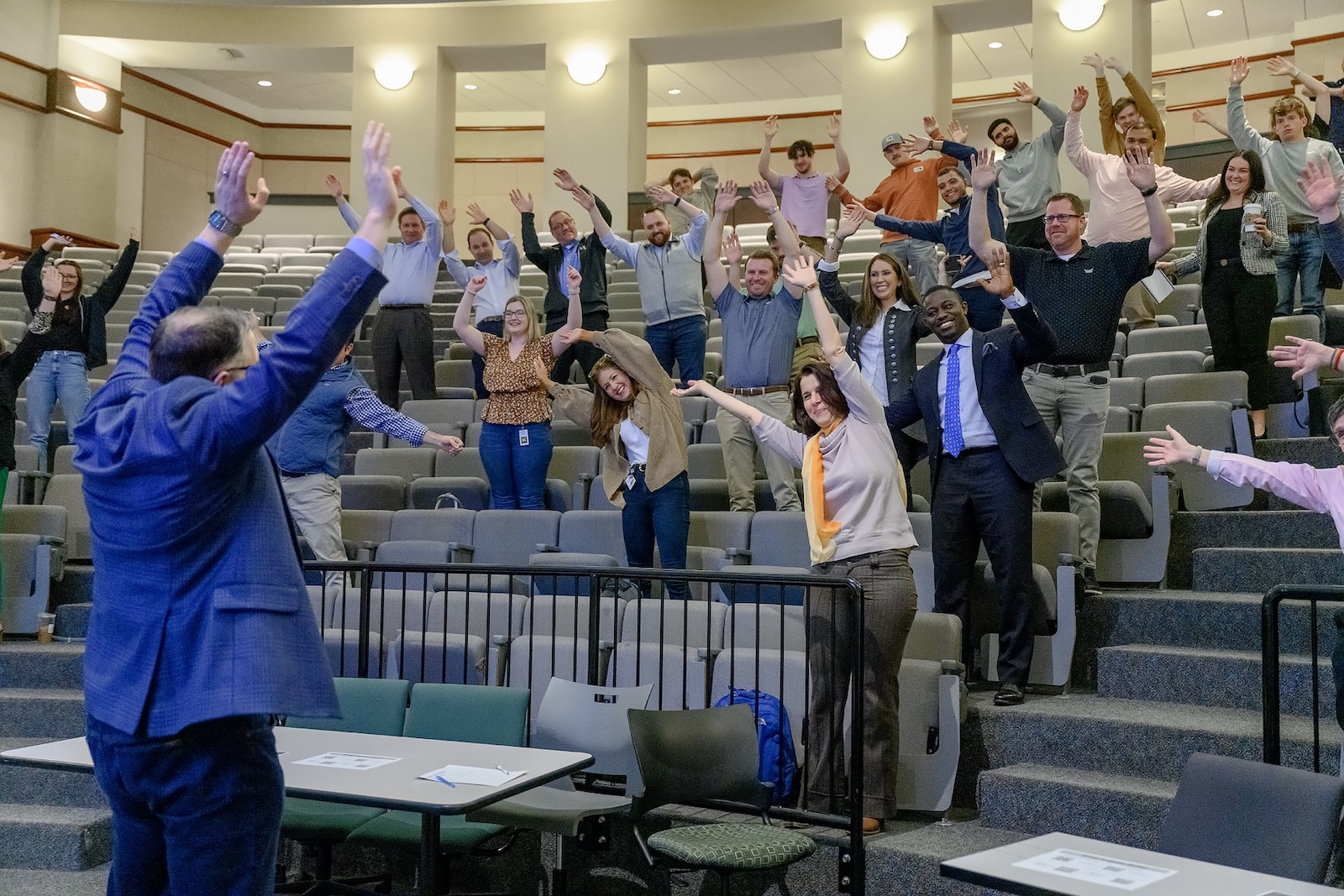 Project Management master's event where participants appear to be stretching