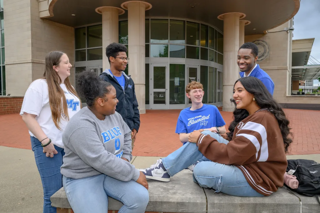 Group of MTSU students sitting and standing outside the Student Union