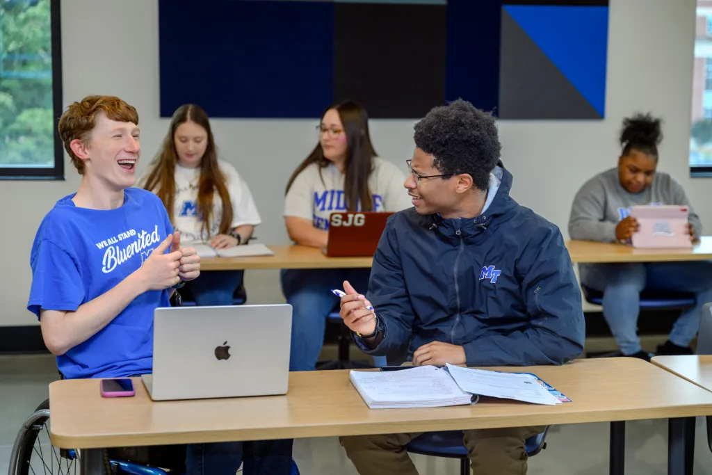 5 students in a classroom wearing MTSU branded clothing